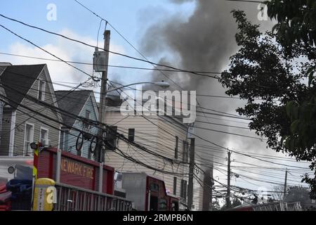 Newark, New Jersey, USA. 29. August 2023. (NEU) zwei-Alarm-Feuer in Newark, New Jersey. 29. August 2023, Newark, New Jersey, USA: Feuerwehrleute kämpften gegen Flammen, die in einem Mehrfamilienhaus durch einen Brand in Newark, New Jersey, ausbrachen. Das zwei-Alarm-Feuer brach in einem dreistöckigen Wohnhaus an der 634 15th Avenue gegen 17:00 Uhr am Dienstag (29) Nachmittag aus. Es wurden keine Verletzungen gemeldet. (Bild: © Kyle Mazza/TheNEWS2 über ZUMA Press Wire) NUR REDAKTIONELLE VERWENDUNG! Nicht für kommerzielle ZWECKE! Stockfoto