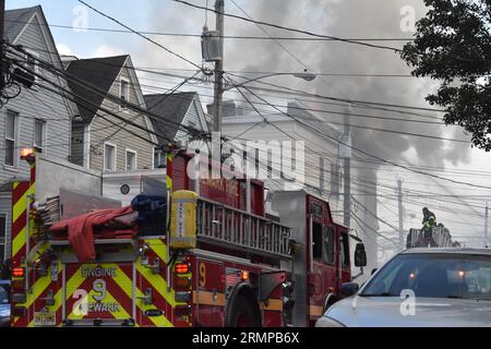 Newark, New Jersey, USA. 29. August 2023. (NEU) zwei-Alarm-Feuer in Newark, New Jersey. 29. August 2023, Newark, New Jersey, USA: Feuerwehrleute kämpften gegen Flammen, die in einem Mehrfamilienhaus durch einen Brand in Newark, New Jersey, ausbrachen. Das zwei-Alarm-Feuer brach in einem dreistöckigen Wohnhaus an der 634 15th Avenue gegen 17:00 Uhr am Dienstag (29) Nachmittag aus. Es wurden keine Verletzungen gemeldet. (Bild: © Kyle Mazza/TheNEWS2 über ZUMA Press Wire) NUR REDAKTIONELLE VERWENDUNG! Nicht für kommerzielle ZWECKE! Stockfoto
