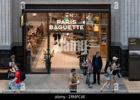 Menschen essen in einem Bäckercafe von Paris Baguette in Turbine Hall A auf dem renovierten Entwicklungsgelände des Battersea Power Station. London, England Stockfoto