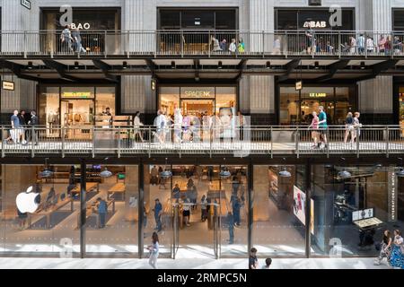 Einkaufsmöglichkeiten in einem Apple Store und anderen Geschäften auf verschiedenen Ebenen in der renovierten Battersea Power Station Turbine Hall A. London, England Stockfoto