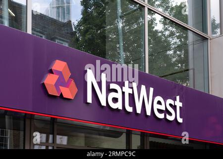 Logo und Titel der NatWest Bank auf der Außenseite einer Filiale in London, Großbritannien. Konzept: Britische Bankenbranche, Hypothekengeschäfte, Zinssätze Stockfoto