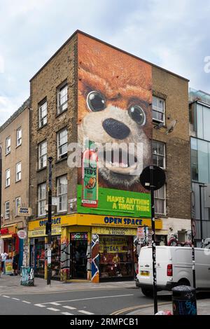 Ein riesiges Wandgemälde eines riesigen Bärenkopfes, das Teds heiße Sauce in einem Backsteingebäude an der Ecke von Brick Lane und Bacon Street, London, Großbritannien, anpricht Stockfoto