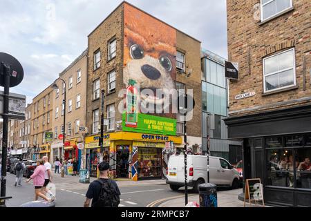 Ein riesiges Wandgemälde eines riesigen Bärenkopfes, das Teds heiße Sauce in einem Backsteingebäude an der Ecke von Brick Lane und Bacon Street, London, Großbritannien, anpricht Stockfoto