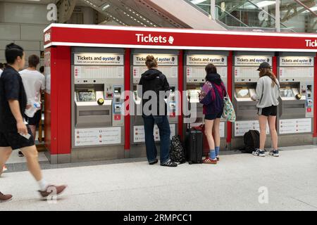 Zugpassagiere, die Tickets an einem Ticketautomat am Bahnhof Liverpool Street, London, kaufen. Thema: Ticketpreise, Preisinflation, Lebenshaltungskosten Stockfoto