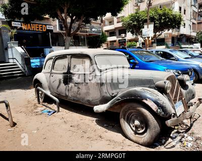 Kairo, Ägypten, 1. August 2023: Altes, altmodisches Fahrzeug im Retro-Stil auf der Straße geparkt, mit neuen Buchstaben und Zahlen auf dem ägyptischen Verkehrsschild; Stockfoto