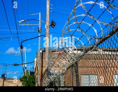 NEW ORLEANS, LOS ANGELES, USA - 22. AUGUST 2023: Ein Zaunzaun, der ein Unternehmen in einer städtischen Umgebung schützt Stockfoto