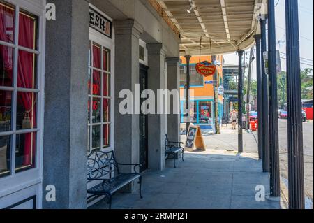 NEW ORLEANS, LA, USA - 27. AUGUST 2023: Downtown Tattoo Parlor mit anderen Gebäuden und Touristen im Hintergrund auf der Frenchmen Street Stockfoto