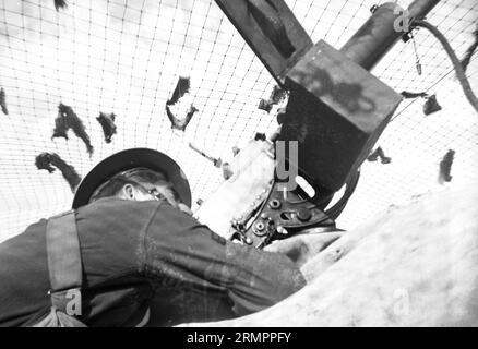 Der Soldat zeigt auf die Flugabwehrkanone. Mitglieder der 114. Infanteriedivision der US-Armee trainieren im Zweiten Weltkrieg gegen Deutschland in Europa. Stockfoto