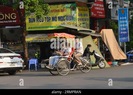 Touristen reisen mit dem Cyclo, um Hanois Altstadt zu besuchen. 越南旅游, वियतनाम पर्यटन, 베트남 관광, ベトナム観光, ឌូលីច វៀតណាម Stockfoto