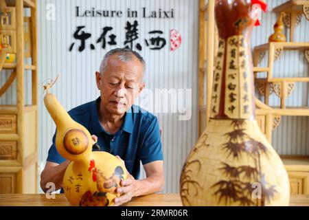 Ein Handwerker zeigt seine Kürbiskunst in der Stadt Laixi in der ostchinesischen Provinz Shandong am 27. August 2023. Stockfoto