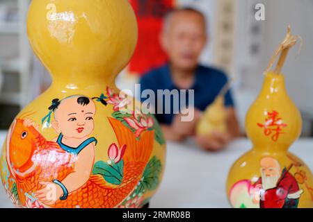 Ein Handwerker zeigt seine Kürbiskunst in der Stadt Laixi in der ostchinesischen Provinz Shandong am 27. August 2023. Stockfoto