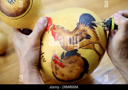 Ein Handwerker zeigt seine Kürbiskunst in der Stadt Laixi in der ostchinesischen Provinz Shandong am 27. August 2023. Stockfoto