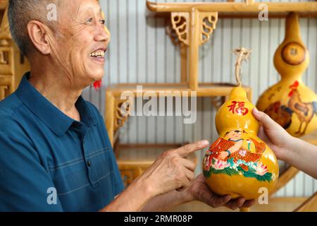 Ein Handwerker zeigt seine Kürbiskunst in der Stadt Laixi in der ostchinesischen Provinz Shandong am 27. August 2023. Stockfoto