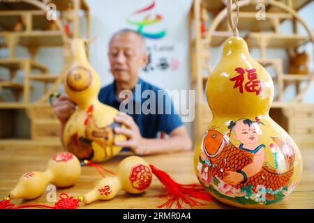 Ein Handwerker zeigt seine Kürbiskunst in der Stadt Laixi in der ostchinesischen Provinz Shandong am 27. August 2023. Stockfoto