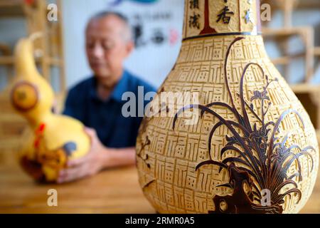 Ein Handwerker zeigt seine Kürbiskunst in der Stadt Laixi in der ostchinesischen Provinz Shandong am 27. August 2023. Stockfoto