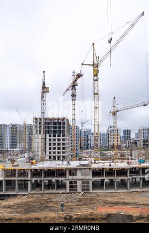 22.08.2023, Barnaul, Russland. Bauarbeiter arbeiten auf großen Baustellen, und es gibt viele Kräne, die im Bereich des Neubaus arbeiten. Stockfoto