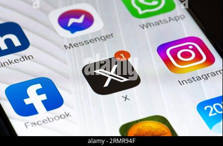 Twitter oder X Initial Logo und App auf einem Smartphone. Online-Social-Media- und Social-Networking-Dienst mit roter Benachrichtigung und anderen Apps Stockfoto