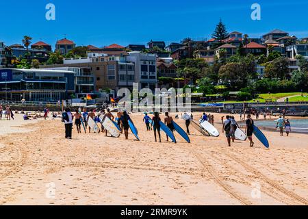 Surfer gehen zurück zum Strand, nach einem Surfunterricht an einem wunderschönen Sommertag in Bondi Beach, Sydney, Australien Stockfoto