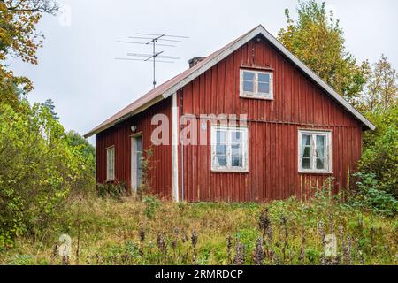 Altes verlassenes Haus mit einem bewachsenen Garten im Herbst Stockfoto