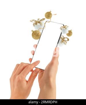 Weibliche Hände halten das Telefon mit leerem Bildschirm. Isoliert, Weihnachtskonzept. Stockfoto