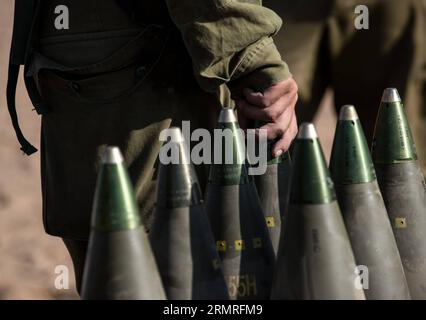 GAZA-GRENZE, Juli 2014 (Xinhua) - ein israelischer Soldat hält am zehnten Tag der Operation Protective Edge, am 17. Juli 2014, die Spitze einer 155mm M109 Dores selbstfahrenden Haubitze auf dem Feld im Süden Israels nahe der Grenze zu Gaza. Das israelische Militär startete am Donnerstagabend nach Tagen schwerer Bombardierung eine Bodenoffensive gegen den von der Hamas kontrollierten Gazastreifen, sagte das Militär. (Xinhua/Li Rui) ISRAEL-GAZA-GRENZFELDOPERATION INNERHALB DES GAZA-STREIFENS PUBLICATIONxNOTxINxCHN Gaza-Grenze Juli 2014 XINHUA an den israelischen Soldaten hält die Spitze einer Shell für eine 155 mm M109 Dores S Stockfoto