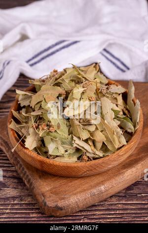 Getrocknete Lindenblüten. Frische Blumen und Lindenblätter in Holzschale. Kräutermedizin Stockfoto