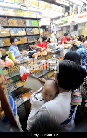 (140721) -- JAKARTA, 21. Juli 2014 (Xinhua) -- Kunden wählen traditionelle Cookies und Snacks für das bevorstehende Eid al-Fitr Festival auf einem Markt in Jakarta, Indonesien, 21. Juli 2014. Die Leute besuchen traditionell Verwandte und Freunde und genießen Outdoor-Unterhaltung während der Eid al-Fitr, die das Ende des heiligen Monats Ramadan markiert. (Xinhua/Agung Kuncahya B.)(cy) INDONESIA-JAKARTA-EID AL-FITR-ZUBEREITUNG PUBLICATIONxNOTxINxCHN Jakarta 21. Juli 2014 XINHUA-Kunden Wählen Sie traditionelle Cookies und Snacks für das bevorstehende Oath Al Fitr Festival AUF einem Markt in Jakarta Indonesien 21. Juli 2014 Cele Stockfoto