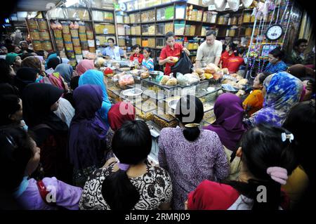 (140721) -- JAKARTA, 21. Juli 2014 (Xinhua) -- Kunden wählen traditionelle Cookies und Snacks für das bevorstehende Eid al-Fitr Festival auf einem Markt in Jakarta, Indonesien, 21. Juli 2014. Die Leute besuchen traditionell Verwandte und Freunde und genießen Outdoor-Unterhaltung während der Eid al-Fitr, die das Ende des heiligen Monats Ramadan markiert. (Xinhua/Agung Kuncahya B.)(cy) INDONESIA-JAKARTA-EID AL-FITR-ZUBEREITUNG PUBLICATIONxNOTxINxCHN Jakarta 21. Juli 2014 XINHUA-Kunden Wählen Sie traditionelle Cookies und Snacks für das bevorstehende Oath Al Fitr Festival AUF einem Markt in Jakarta Indonesien 21. Juli 2014 Cele Stockfoto