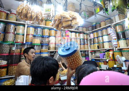 (140721) -- JAKARTA, 21. Juli 2014 (Xinhua) -- Kunden wählen traditionelle Cookies und Snacks für das bevorstehende Eid al-Fitr Festival auf einem Markt in Jakarta, Indonesien, 21. Juli 2014. Die Leute besuchen traditionell Verwandte und Freunde und genießen Outdoor-Unterhaltung während der Eid al-Fitr, die das Ende des heiligen Monats Ramadan markiert. (Xinhua/Agung Kuncahya B.)(cy) INDONESIA-JAKARTA-EID AL-FITR-ZUBEREITUNG PUBLICATIONxNOTxINxCHN Jakarta 21. Juli 2014 XINHUA-Kunden Wählen Sie traditionelle Cookies und Snacks für das bevorstehende Oath Al Fitr Festival AUF einem Markt in Jakarta Indonesien 21. Juli 2014 Cele Stockfoto