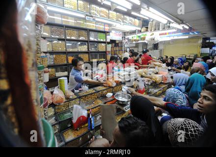 (140721) -- JAKARTA, 21. Juli 2014 (Xinhua) -- Kunden wählen traditionelle Cookies und Snacks für das bevorstehende Eid al-Fitr Festival auf einem Markt in Jakarta, Indonesien, 21. Juli 2014. Die Leute besuchen traditionell Verwandte und Freunde und genießen Outdoor-Unterhaltung während der Eid al-Fitr, die das Ende des heiligen Monats Ramadan markiert. (Xinhua/Agung Kuncahya B.)(cy) INDONESIA-JAKARTA-EID AL-FITR-ZUBEREITUNG PUBLICATIONxNOTxINxCHN Jakarta 21. Juli 2014 XINHUA-Kunden Wählen Sie traditionelle Cookies und Snacks für das bevorstehende Oath Al Fitr Festival AUF einem Markt in Jakarta Indonesien 21. Juli 2014 Cele Stockfoto