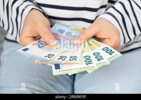 Verschiedene Stückelungen von Euro-Banknoten in den Händen einer Person, zwanzig, fünfundfünfzig und hundert Euro. Stockfoto