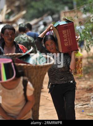 (140805) -- LUDIAN, 5. August 2014 -- Menschen transportieren Hilfsgüter für Katastrophen in der Longtoushan Township des Ludian County, Provinz Yunnan im Südwesten Chinas, 5. August 2014. Das Erdbeben der Stärke 6,5, das das Ludian County von Yunnan am Sonntagnachmittag erschütterte, hat mindestens 410 Menschen getötet, 12 vermisst und mehr als 2.300 andere verletzt. ) (Ry) CHINA-YUNNAN-EARTHQUAKE-RESCUE(CN) XuexYubin PUBLICATIONxNOTxINxCHN 5. August 2014 Berühmtheiten übermitteln HILFSGÜTER FÜR Katastrophen in der Gemeinde County Südwest-China Provinz S Yunnan 5. August 2014 das Erdbeben der Stärke 6 5 Thatcher hat Yunnan S County AUF Su getroffen Stockfoto