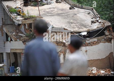 (140805) -- LUDIAN, 5. Aug. 2014 -- Menschen schauen auf ein eingestürztes Haus in der Longtoushan Township des Ludian County, Südwestchinesische Provinz Yunnan, 5. Aug. 2014. Das Erdbeben der Stärke 6,5, das das Ludian County von Yunnan am Sonntagnachmittag erschütterte, hat mindestens 410 Menschen getötet, 12 vermisst und mehr als 2.300 andere verletzt. ) (Ry) CHINA-YUNNAN-EARTHQUAKE-RESCUE(CN) XuexYubin PUBLICATIONxNOTxINxCHN 5. August 2014 Prominente Schauen Sie sich ein eingestürztes Haus in der Gemeinde County Südwest China S Yunnan Provinz 5. August 2014 das Erdbeben der Stärke 6 5 Thatcher traf Yunnan County AM Sonntag Mittag Stockfoto