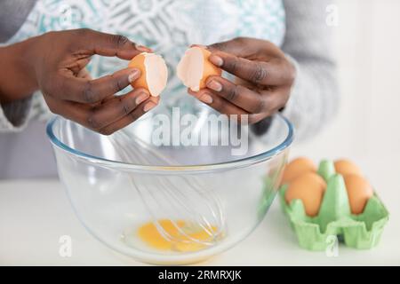 Hände brechen Ei in eine Schüssel Stockfoto