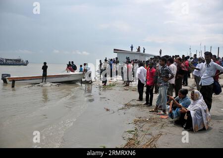 (140806) -- MAWA, 6. August 2014 -- Bangladeshi-Menschen warten zwei Tage nach dem Fährunfall auf dem Padma-Fluss im Bezirk Munshiganj, etwa 37 km von der Hauptstadt Dhaka, Bangladesch, 6. August 2014 auf Leichen von Opfern am Ufer des Padma-Flusses. Die Zahl der Todesopfer der Fähre am Montag in Bangladeschs zentralem Bezirk Munshiganj ist am Mittwochmorgen auf 11 gestiegen, nachdem weitere sieben Leichen weit weg von dem Ort, an dem das Schiff mit etwa 250 Passagieren an Bord sank, abgeholt wurden, sagte die Polizei. ) (lmz) BANGLADESCH-DHAKA-FÄHRE-UNFALL SharifulxIslam PUBLICATIONxNOTxINxCHN Mawa 6. August 2014 B Stockfoto