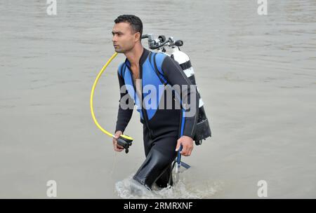 (140806) -- MAWA, 6. August 2014 -- Ein bangladeschischer Fahrer durchsucht den Ort zwei Tage nach dem Fährunfall auf dem Padma River im Bezirk Munshiganj, etwa 37 km von der Hauptstadt Dhaka, Bangladesch, 6. August 2014. Die Zahl der Todesopfer der Fähre am Montag in Bangladeschs zentralem Bezirk Munshiganj ist am Mittwochmorgen auf 11 gestiegen, nachdem weitere sieben Leichen weit weg von dem Ort, an dem das Schiff mit etwa 250 Passagieren an Bord sank, abgeholt wurden, sagte die Polizei. ) (lmz) BANGLADESCH-DHAKA-FÄHRE-UNFALL SharifulxIslam PUBLICATIONxNOTxINxCHN Mawa Aug 6 2014 ein Bangladeshi Fahrer Suchen Sie den Ort Stockfoto