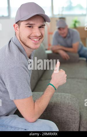 Junger gutaussehender lächelnder Mover in Uniform Stockfoto