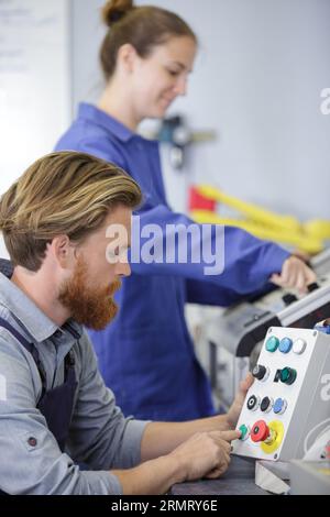 Ingenieurin, die die Auszubildende in den Umgang mit der cnc-Maschine einweist Stockfoto