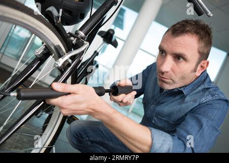 Ein Mann, der einen Fahrradreifen aus nächster Nähe an den Händen pumpt Stockfoto