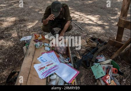 SÜD-ISRAEL, 6. August 2014 -- ein israelischer Soldat packt Nahrung und Notwendigkeiten mit einer Sammlung von Gemälden ein, die Kinder aus Kindergärten aus der zentralisraelischen Stadt Natanya, im südlichen Israel, das an den Gazastreifen grenzt, am 6. August 2014 geschickt haben. Israel hat sich bereit erklärt, den Waffenstillstand im Gazastreifen mit der palästinensischen Hamas-Bewegung zu verlängern, berichtete das ägyptische Staatsfernsehen am späten Mittwoch. Und ein israelischer Beamter, der um Anonymität bittet, hat Xinhua bestätigt, dass beide Seiten zugestimmt haben, den gegenwärtigen Waffenstillstand bedingungslos zu verlängern. ) (ZHF) ISRAEL-GAZA-STREIFEN-WAFFENSTILLSTANDSVEREINBARUNG LIXRUI PU Stockfoto