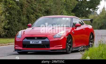 Whittlebury, Northants, UK - 27. August 2023: 2009,rot,Nissan GTR-Auto, das auf einer englischen Landstraße fährt Stockfoto