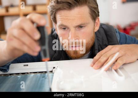 Junger Ingenieur, der mit einem Metallblech arbeitet Stockfoto