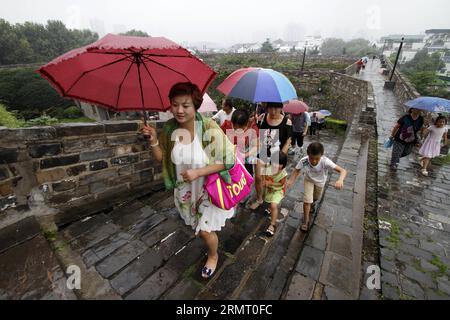 Touristen besuchen das Zhonghuamen-Tor, eine Barbakane, die Teil der alten Stadtmauer von Nanjing ist, der Hauptstadt der ostchinesischen Provinz Jiangsu, 8. August 2014. Die Stadtmauer von Nanjing wurde zwischen 1366 und 1386, den frühen Jahren der Ming-Dynastie (1368–1644), errichtet. Nanjing war einst die Hauptstadt der Dynastie und wurde von vier Schichten aus Ziegelsteinmauern umschlossen. Nach sechs Jahrhunderten natürlicher Erosion und absichtlicher Zerstörung durch Menschen beträgt die Länge der verbliebenen Stadtmauer heute 25 Kilometer, was noch heute einen Weltrekord darstellt. () (LMM) CHINA-JIANGSU-NANJING-CITY WALL-TOURISM (CN) XINHUA PUBLIC Stockfoto