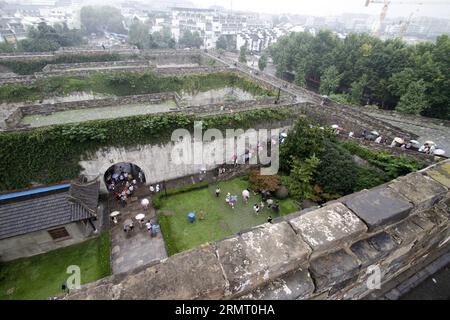 Touristen besuchen das Zhonghuamen-Tor, eine Barbakane, die Teil der alten Stadtmauer von Nanjing ist, der Hauptstadt der ostchinesischen Provinz Jiangsu, 8. August 2014. Die Stadtmauer von Nanjing wurde zwischen 1366 und 1386, den frühen Jahren der Ming-Dynastie (1368–1644), errichtet. Nanjing war einst die Hauptstadt der Dynastie und wurde von vier Schichten aus Ziegelsteinmauern umschlossen. Nach sechs Jahrhunderten natürlicher Erosion und absichtlicher Zerstörung durch Menschen beträgt die Länge der verbliebenen Stadtmauer heute 25 Kilometer, was noch heute einen Weltrekord darstellt. () (LMM) CHINA-JIANGSU-NANJING-CITY WALL-TOURISM (CN) XINHUA PUBLIC Stockfoto