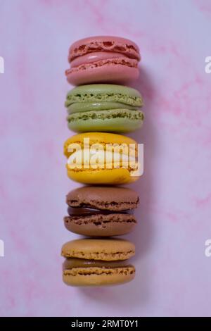 Bunte Macarons auf rosafarbenem Marmor Stockfoto