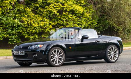 Whittlebury, Northants, UK - 27. August 2023: 2008 schwarzes Mazda MX5 Auto, das auf einer englischen Landstraße fährt Stockfoto