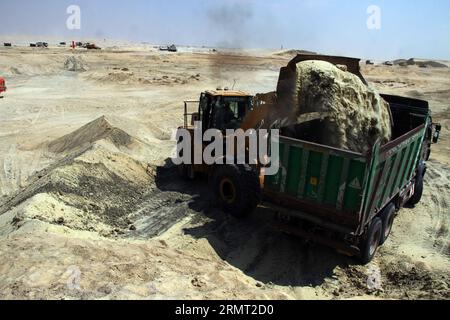 (140811) -- ISMAILIA, 10. August 2014 -- ein ägyptischer Arbeiter trägt Sand auf der Baustelle des neuen Suez-Kanal-Projekts in der Hafenstadt Ismailia, nordöstlich von Kairo, Ägypten, am 10. August 2014. Der ägyptische Präsident Abdel Fattah al-Sisi stellte am vergangenen Dienstag den Bau eines 72 km langen neuen Suez-Kanals vor, der den Verkehr entlang der bestehenden Wasserstraße, die das Rote Meer mit dem Mittelmeer verbindet, beschleunigen und die geschwächte Wirtschaft Ägyptens ankurbeln soll. ) ÄGYPTEN-KAIRO-ISMAILIA-NEW SUZE CANAL AhmedxGomaa PUBLICATIONxNOTxINxCHN Ismailia Aug 10 2014 to Egyptian Worker trägt Sand AUF der Baustelle Stockfoto