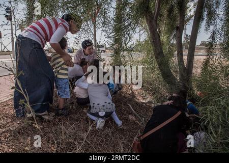 (140811) -- GAZA BORDER, 10. August 2014 -- Israelis decken sich am Straßenrand, als Warnsirenen für eintreffende Raketen in der Nähe der israelischen Stadt Sderot, Süd-Israel, das am 10. August 2014 an den Gazastreifen grenzt, ertönt. Israelische Beamte akzeptierten den ägyptischen Vorschlag, einen weiteren 72-stündigen Waffenstillstand ab Montag um 1 Uhr Ortszeit (2200 GMT) durchzuführen, teilte ein israelischer Beamter Xinhua mit. /Albert Sadikov) ISRAEL-GAZA-72-STUNDEN WAFFENSTILLSTANDSANNAHME JINI PUBLICATIONxNOTxINxCHN Gaza-Grenze 10. August 2014 Israelis decken sich am Straßenrand als Warnsirene für eintreffende Raketen in der Nähe von Israel Stockfoto