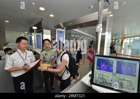 (140812) -- NANJING, 12. August 2014 -- Mitarbeiter der Zoll- und Quarantäneabteilung verteilen Broschüren über die Prävention der Ebola-Viruserkrankung an Passagiere, die am Lukou International Airport in Nanjing, der Hauptstadt der ostchinesischen Provinz Jiangsu, am 12. August 2014 ankommen. Um zu verhindern, dass das tödliche Ebola-Virus in China eindringt, öffnet der Zoll von Nanjing eine ausgewiesene Passage für Reisende, die in den letzten 21 Tagen am Lukou International Airport nach Westafrika gereist sind. ) (lfj) CHINA-JIANGSU-NANJING-EBOLA PREVENTION (CN) XiexMingming PUBLICATIONxNOTxINxCHN Nanjing 12. August 2014 Zoll- und Quarantänepersonal Stockfoto