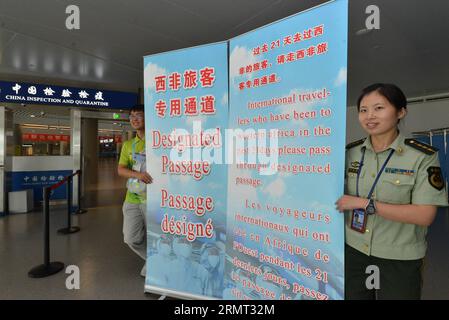 (140812) -- NANJING, 12. August 2014 -- Mitarbeiter des Zoll- und Quarantänepersonals stehen neben einer Tafel, die die ausgewiesene Passage am Lukou International Airport in Nanjing, der Hauptstadt der ostchinesischen Provinz Jiangsu, zeigt, 12. August 2014. Um zu verhindern, dass das tödliche Ebola-Virus in China eindringt, öffnet der Zoll von Nanjing eine ausgewiesene Passage für Reisende, die in den letzten 21 Tagen am Lukou International Airport nach Westafrika gereist sind. ) (lfj) CHINA-JIANGSU-NANJING-EBOLA PREVENTION (CN) XiexMingming PUBLICATIONxNOTxINxCHN Nanjing 12. August 2014 Mitarbeiter des Zoll- und Quarantänepersonals stehen neben einem Vorstand Stockfoto